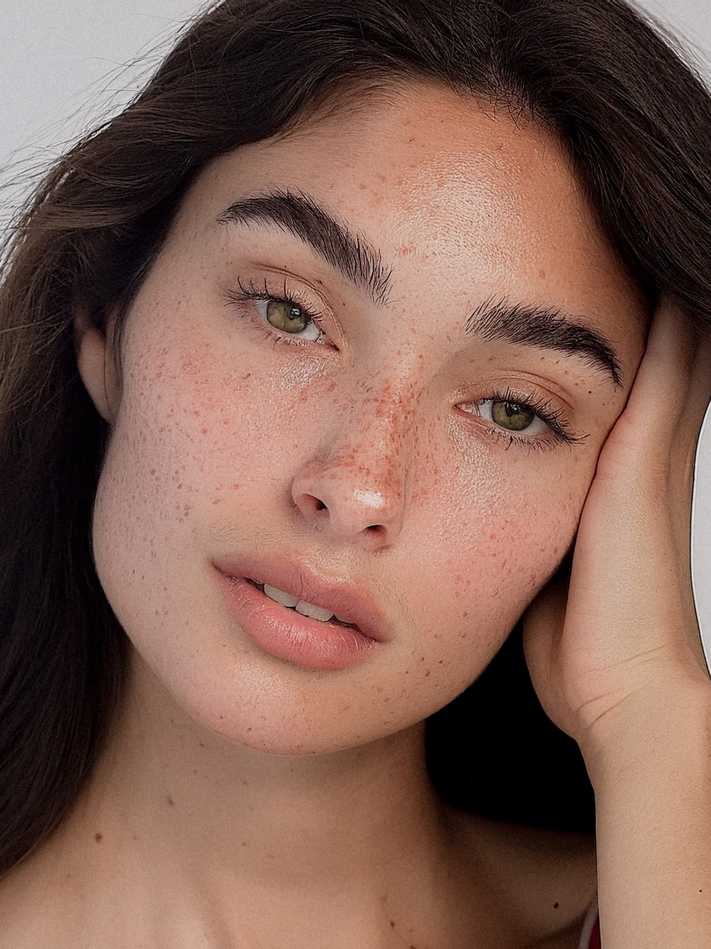 Model with natural freckles and clear, hydrated skin